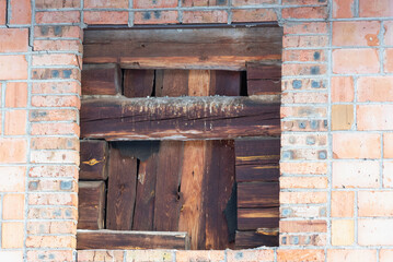 A blocked window in a brick house.