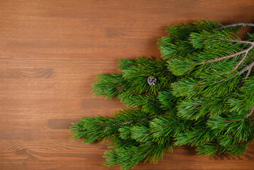 Christmas tree branch on wooden background. Xmas and Happy New Year theme. Flat lay, top view. Copy space