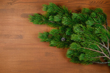 Christmas tree branch on wooden background. Xmas and Happy New Year theme. Flat lay, top view. Copy space