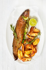 baked trout fish with roast potatoes, top view