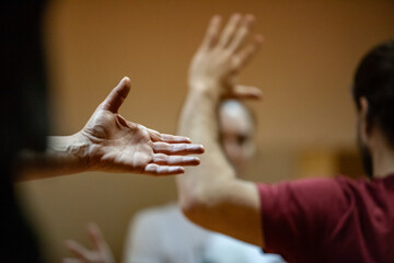 opened palm on blurred bg of moving performers dancer hand, dance performance improvisation