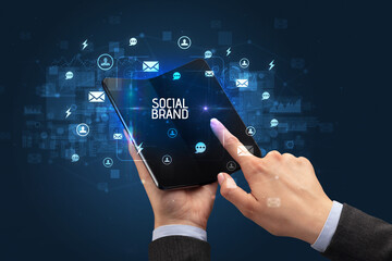 Businessman holding a foldable smartphone, social media concept