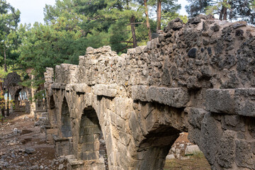 ruins of Roman aqueduct among the forest in the ancient city of Phaselis