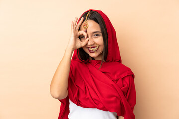 Young Indian woman isolated on beige background showing ok sign with fingers