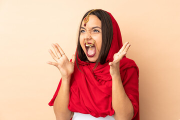 Young Indian woman isolated on beige background with surprise facial expression