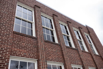 Low angle view of a red brick school building, with lots of windows on an overcast dayday