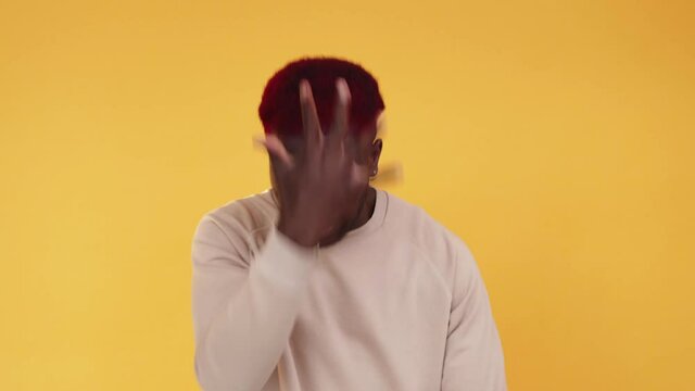Face palm. Angry man. Failure stress. Boomerang animation. Frustrated furious annoyed African guy with mistake despair expression isolated on orange background GIF loop motion.