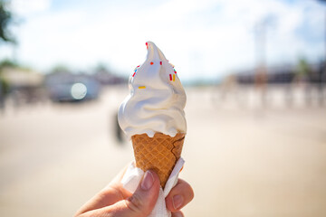 Girl'S Hand Holding Ice Cream In Waffle Cone Decorated With Pills a hot day outside