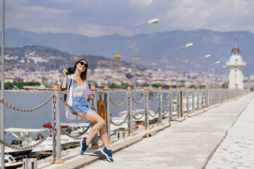 Turkey travel tourist woman on vacation in the Alanya sitting on embankment. Turkey summer destination.