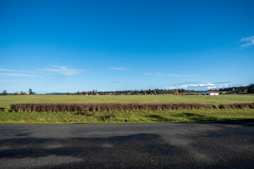 Fototapeta na wymiar Wide, scenic view of a white barn on a large plot of farm land in the Pacific Northwest