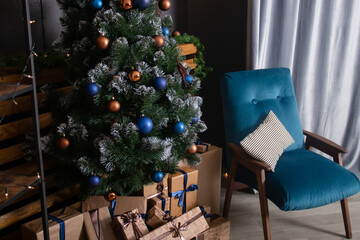 Stylish loft room interior with beautiful Christmas tree. dark blue and brown and gold colors. new years atmosphere decoration