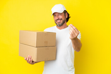 Delivery senior dutch man isolated on yellow background making money gesture