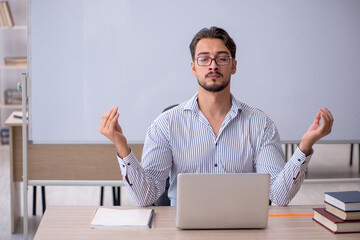 Young male teacher in the classroom