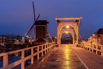 An old wooden mill on the banks of a canal in Leiden at dawn.