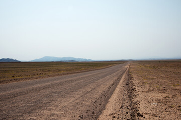 Sandy empty road crossing the namibian desert. Namibia