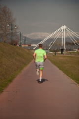 Male sportsman is jogging on his trail