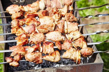 Marinated shashlik preparing on a barbecue grill over charcoal. Traditional Russian shashlik on a barbecue skewer