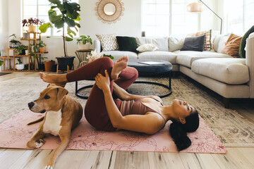 Fit Woman Practicing Yoga By Dog At Home