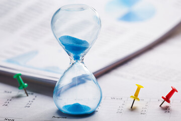 Best time for investment. Hourglass, financial charts, calculator and calendar with pins.