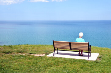 Senior Woman on Bench by Lake