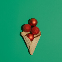Christmas decoration creative idea with red baubles on dark green background. Minimal winter and New Year celebration idea, visual season and food concept.