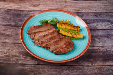 Sliced sirloin Steak Roast Beef on a dark wooden table background.