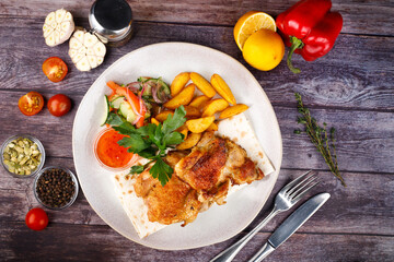 fried chicken with potatoes in a white plate