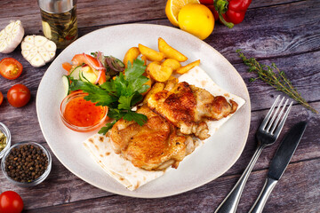 fried chicken with potatoes in a white plate