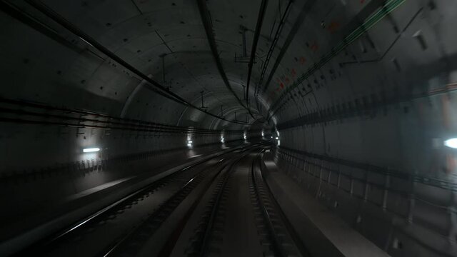 Front cabin view of driverless metro train moving forward through underground tunnel. Automated advanced transportation system, subway in Copenhagen, Denmark.