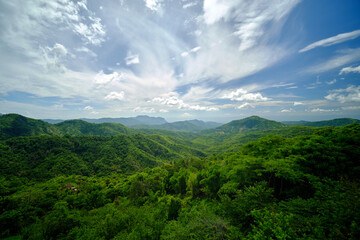 wide angle landscape greenery forest hills with cloudy blue sky