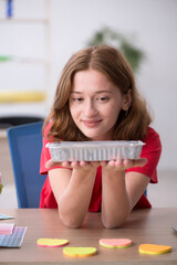 Young female designer having breakfast in the office