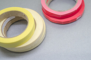Several rollers of adhesive tape for different purposes. Paint and duct tape. Selective focus.