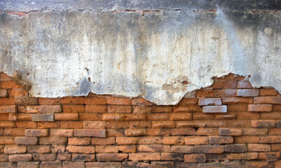 Old brick wall with peeling plaster