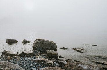 Rocky beach of Lake Ontario on a gray foggy day.