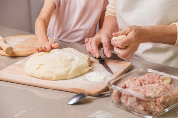 grandmother and girl preparing a meat dish
