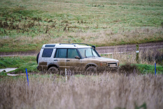 Land Rover Discovery 4x4 Off-road Vehicle Driving Across Mud, Water-logged Terrain And Wading Through Deep Water Pools, Wilts UK. 