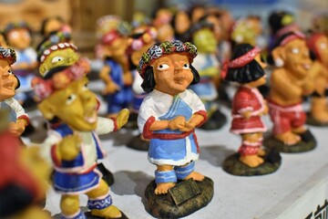 Small ornamental figurines of indigenous people wearing colorful traditional clothing