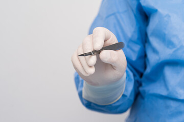 surgery, medicine and people concept - close up of surgeons hands with scalpel at operation in...