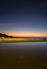 Naklejka na ściany i meble Sunset along the ocean beach in summer