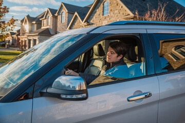 Teenage boy sitting in driver's seat of vehicle learning to drive.