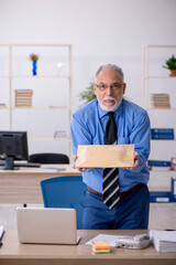 Old male employee receiving parcel via Internet