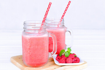 Raspberry smoothie red colorful fruit juice milkshake blend beverage healthy high protein the taste yummy In glass drink episode morning on white wood background.