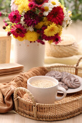 Fototapeta na wymiar Cup of hot coffee, delicious cookies and beautiful bouquet on wooden table