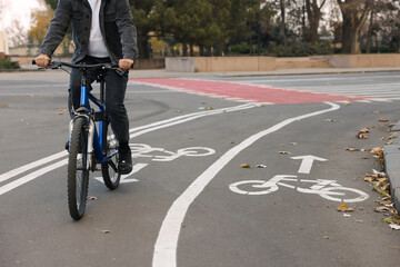 Fototapeta na wymiar Man riding bicycle on lane in city, closeup