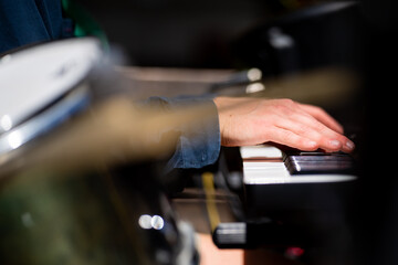 close up of musician playing keyboard and piano, in a band, at a music gig, in Australia.