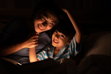 young Asian mother and little daughter girl on bed, cozy love sleepy at childhood home, at night