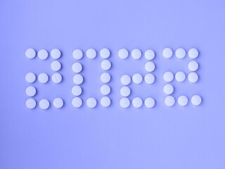 2022 Happy New Year banner for health care and medical concept. Number 2022 made from tablets on very peri purple background. View from above flat lay. Medical concept in trend 2022 color
