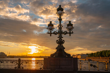 Fototapeta premium The lantern of the Trinity Bridge and the Palace Embankment in the first rays of the sun, Saint Petersburg, Russia