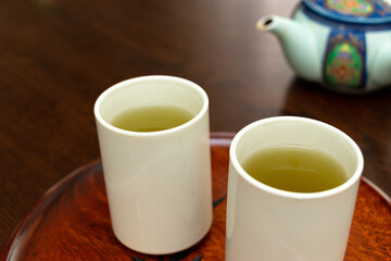 Obraz na płótnie Canvas 緑茶が入った二つの白いコップ