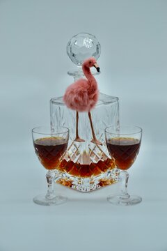 Fluffy Pink Flamingo In Retro Setting With Crystal Decanter And Port Or Sherry Wine Glasses